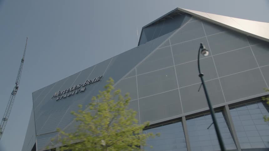The exterior of a stadium gleams in the sunlight