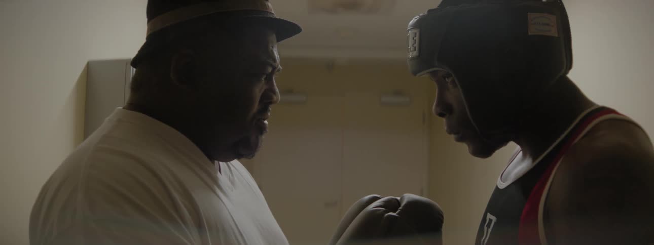 A coach is giving a pre-match talk to a boxer