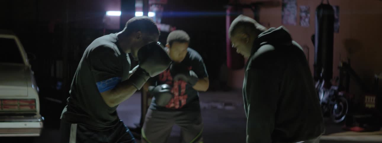 Three men practice boxing