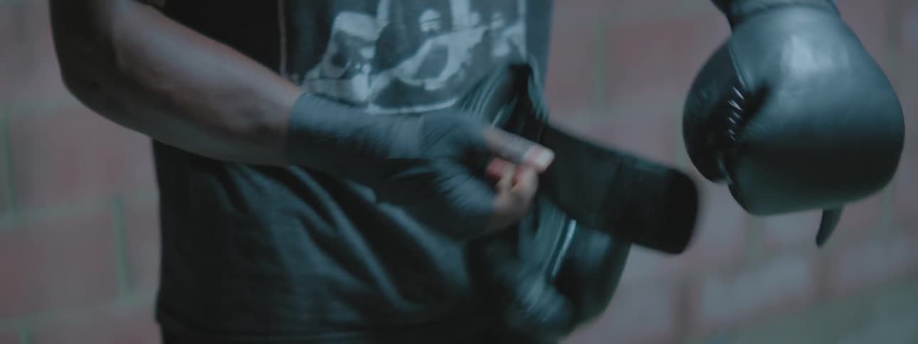 A fighter is putting on boxing gloves