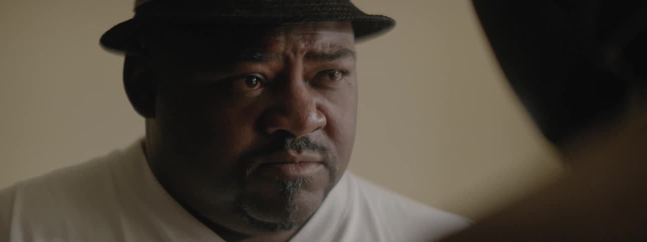 A man talks while wearing a hat