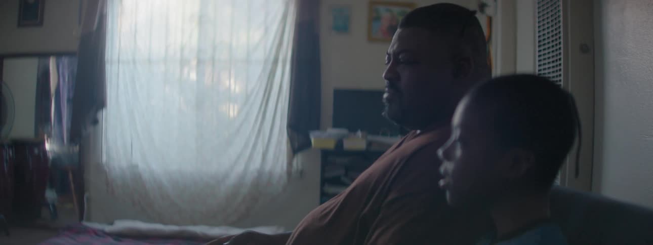 Man and child talk while sitting on a couch