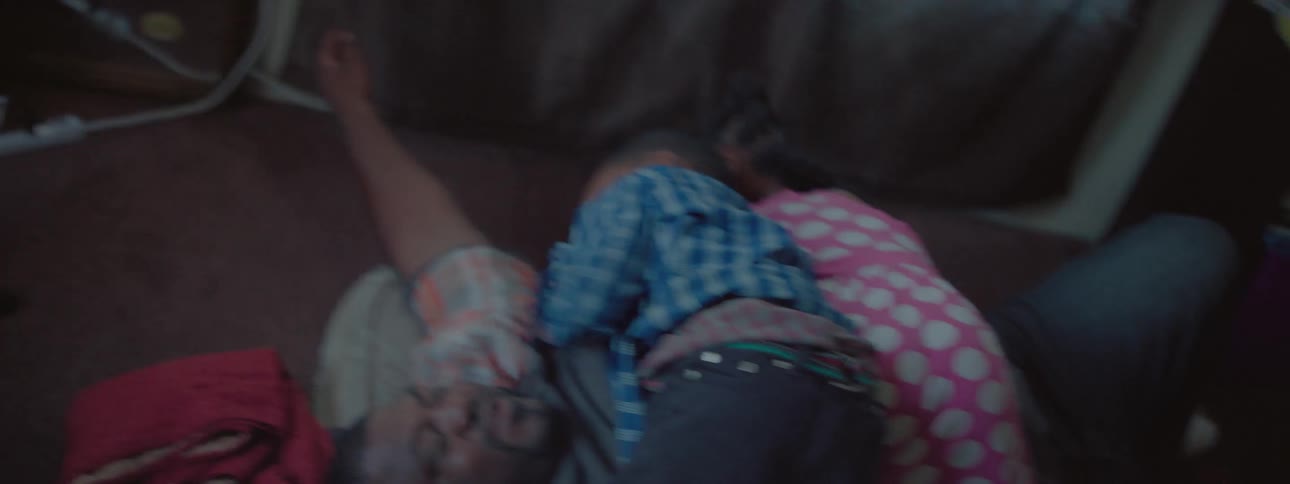 Two children jump on a man on a bed