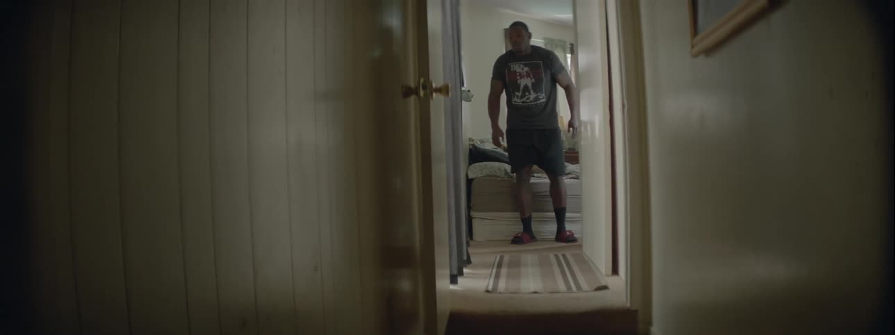 A man puts on his slippers as he gets up from bed