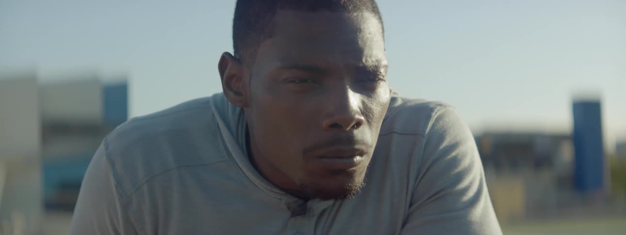 A man in a sweatshirt stretches and rolls his neck