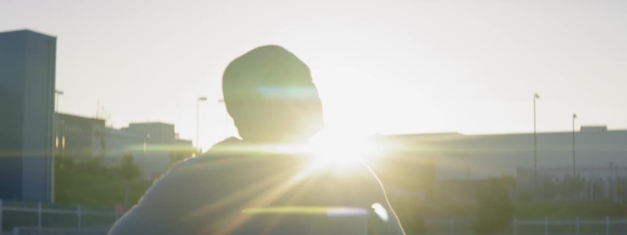 A mean breathes heavily on a racetrack at sunset