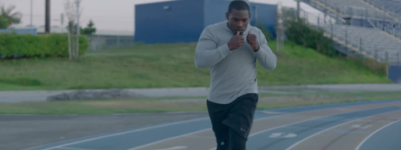 A man punches while running on a track