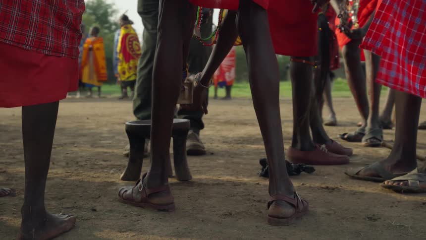 Maasai stand around a small stool