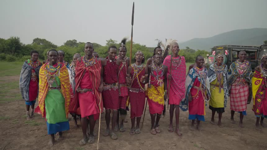 Maasai dressed in colorful clothing dance around