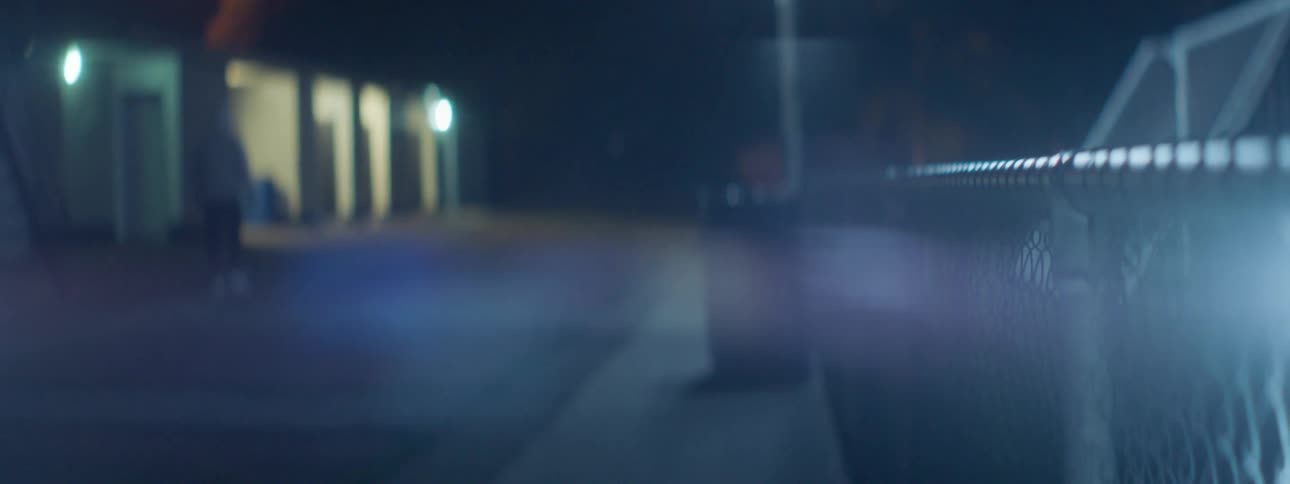 A man walks down a dark city street
