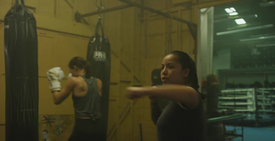 A coach shows a female fighter a series of punches