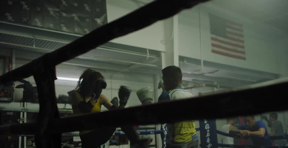 Man and woman spar in a boxing ring
