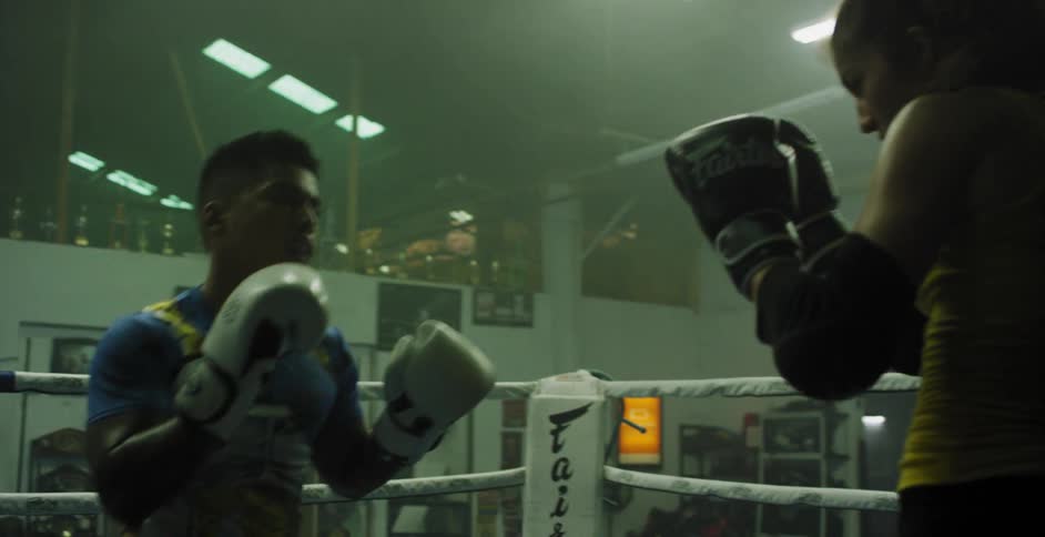 A man and woman are sparring in the ring