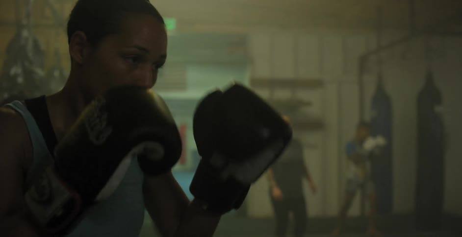 Woman practices punching and hits a heavy bag