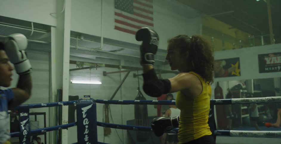 A man and woman spar in a boxing ring