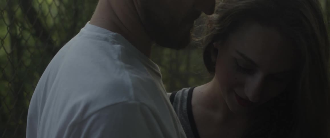 Man and woman kiss near trees