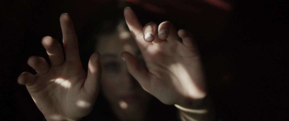 A woman raises her hands towards the light