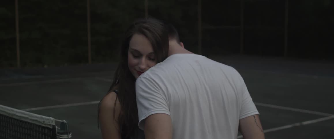 A couple hug outside smiling