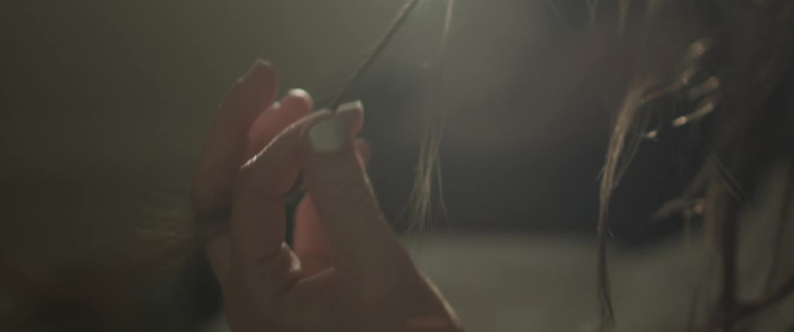 A woman twirls her hair outside