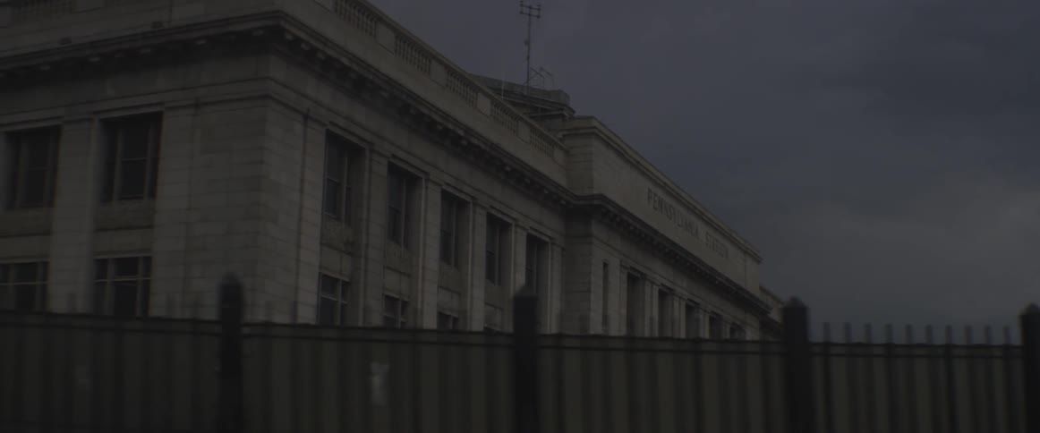 A government building sits behind a metal fence