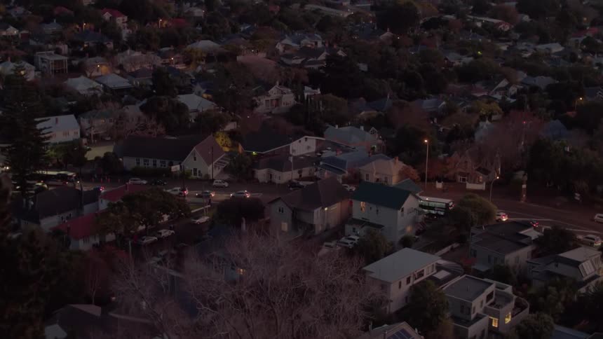 Traffic backs up on a suburban street at dusk