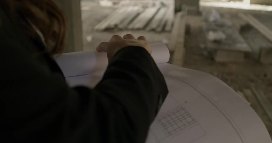 A woman flips through building plans