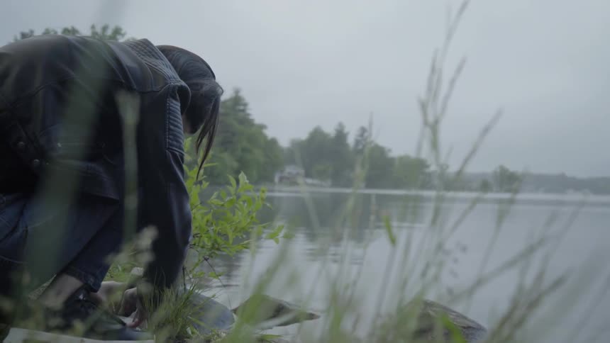 A girl uses her phone to get a close up photograph of a pond
