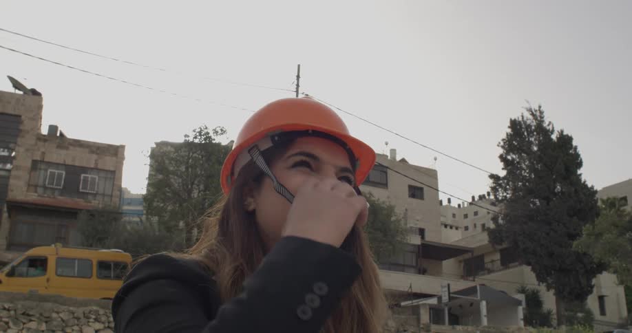 Woman places construction hat on her head