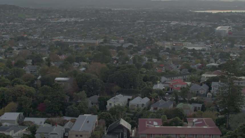 Houses cover the landscape below a hill