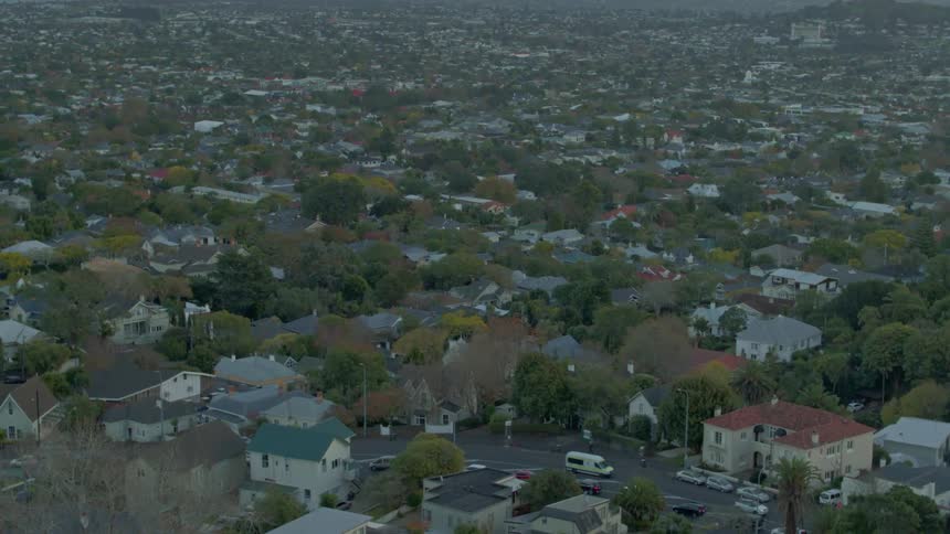 Vehicles pass by on a neighborhood street