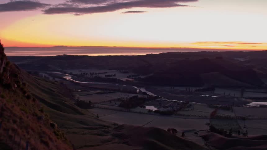 The sun sets above a hill