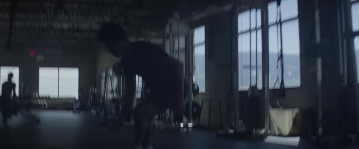 A man is running sprints inside a gym during the day
