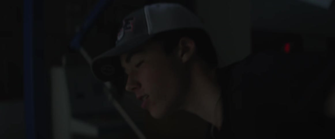 Boy in baseball cap throws something