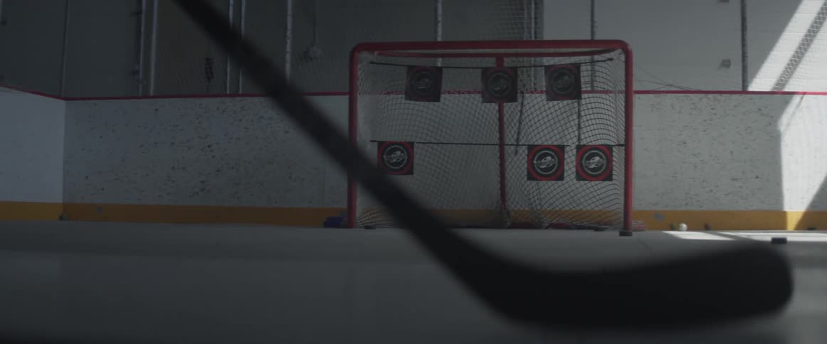 A hockey player is practicing shooting the puck