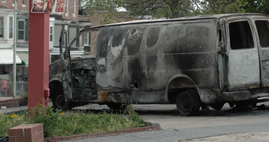 A destroyed van sits on a residential area