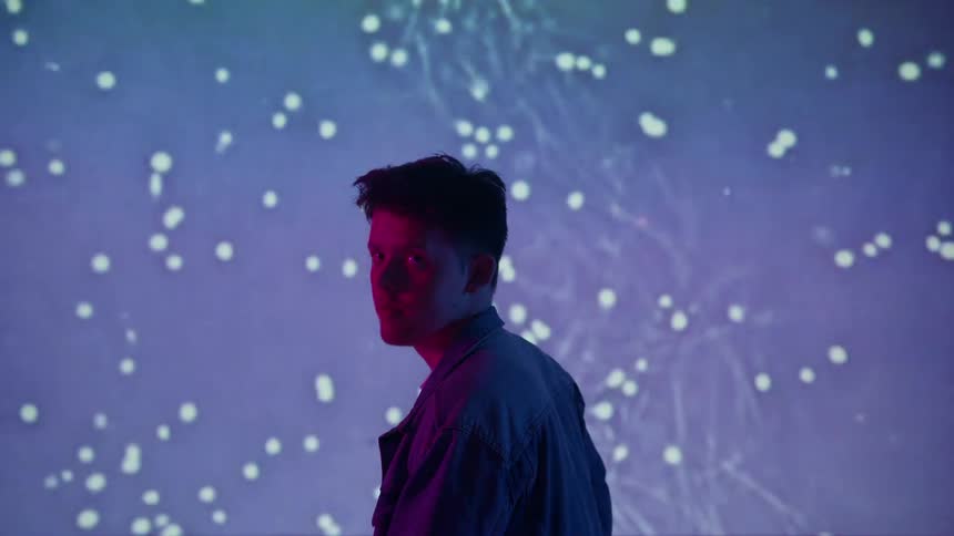 A man stands in front of a flashing wall