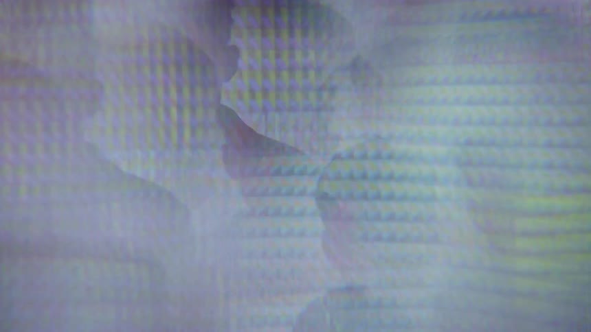 A man's image refracts and spins in abstract