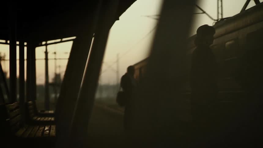 People waiting for a train at an outdoor station