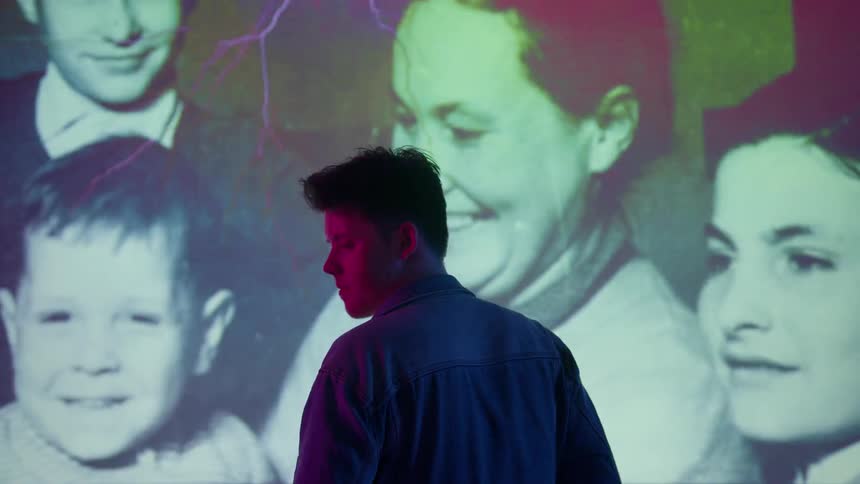 Man stands in front of a screen with constantly changing pictures