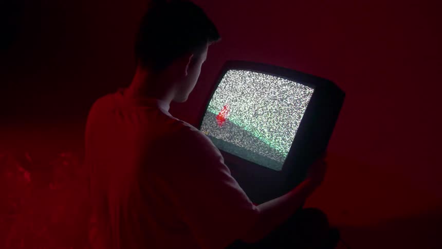 A man holds a static filled television