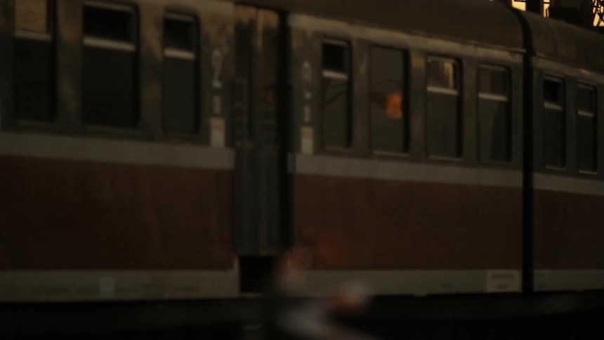 A commuter train shown in closeup leaving a stop