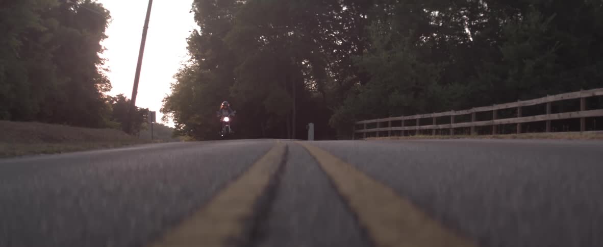 Woman on a motorcycle travels down the road