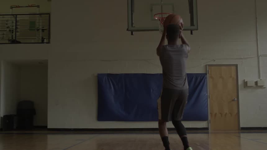 A man practices basketball shots