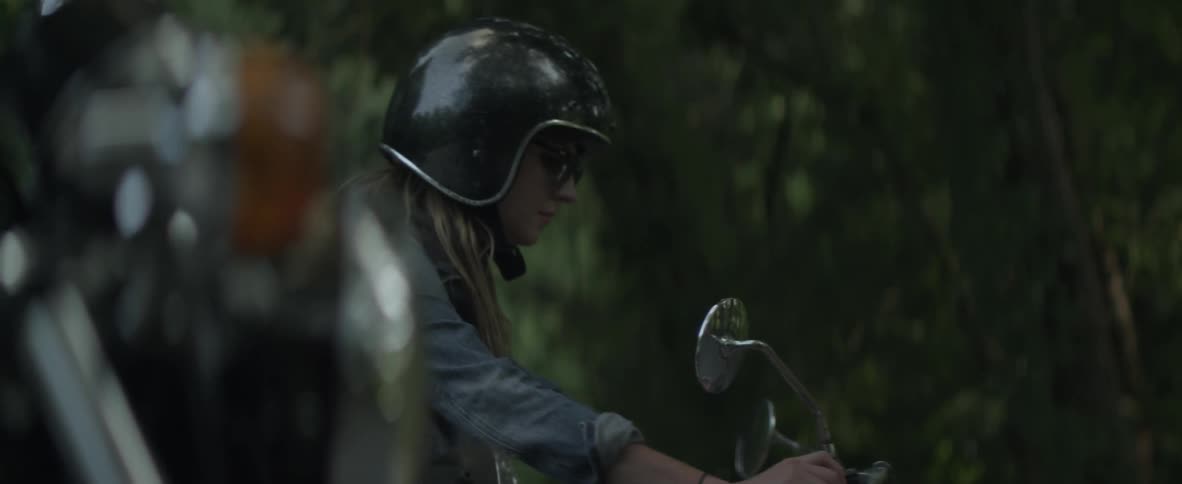 A woman parks her motorcycle