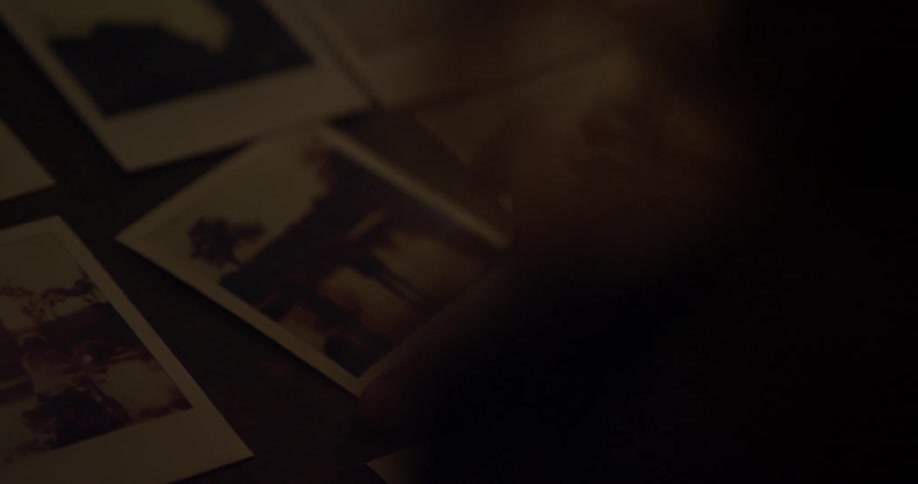 A hand picks up a polaroid picture