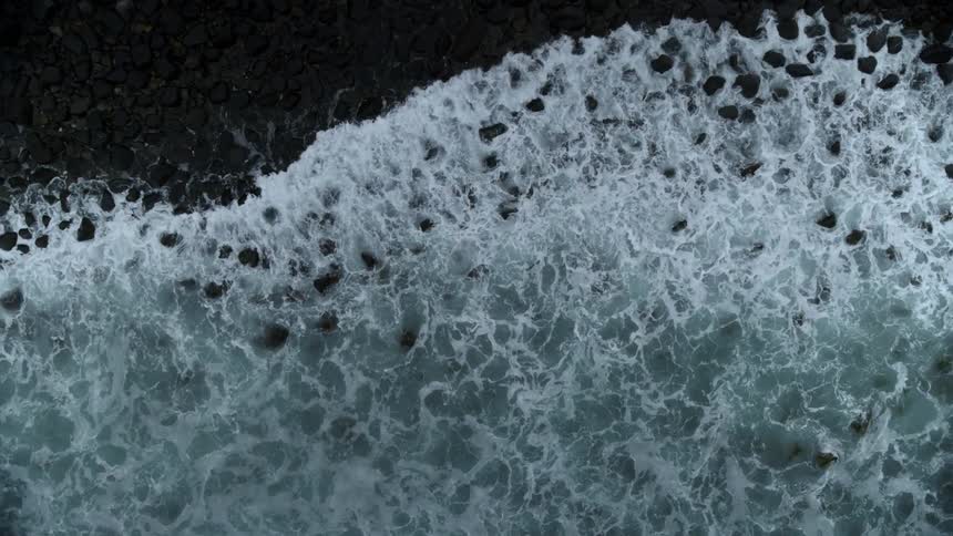 Waves roll onto the shore of a rocky beach