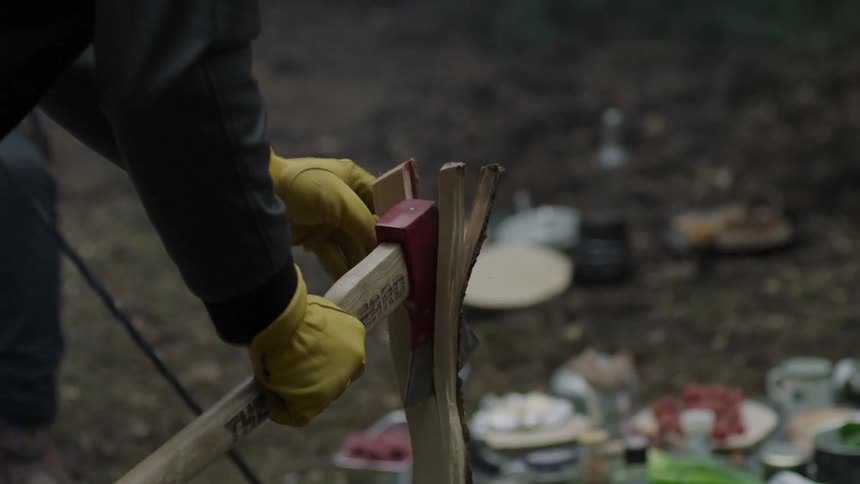 A person is splitting a log with an axe