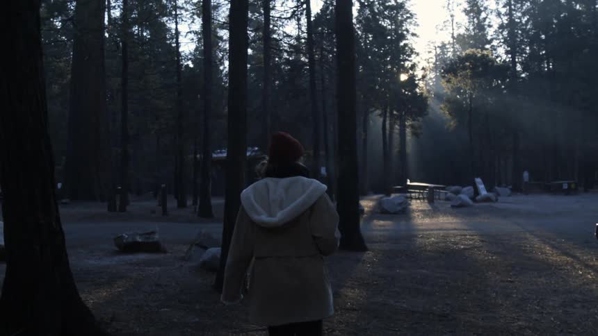 A woman is walking through a campground on a cold morning
