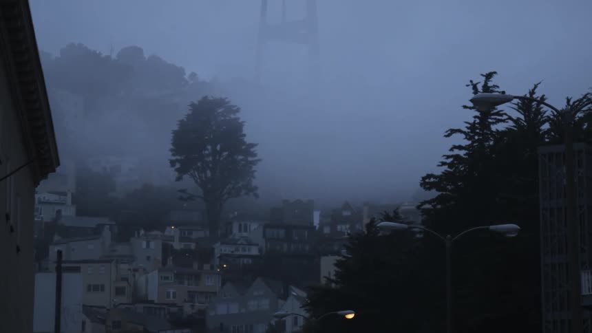 Fog sits above the houses on a hillside