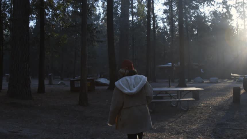 A person walks towards a campsite